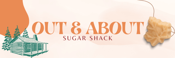 A promotional banner for an 'Out & About' event at a Sugar Shack. The background is a soft beige with organic, flowing shapes in warm orange tones. On the left side, there is a green illustration of a traditional log cabin surrounded by pine trees. The main text, 'OUT & ABOUT,' is written in bold, orange serif letters, while 'SUGAR SHACK' appears in smaller, red uppercase letters below. On the right side, a maple leaf-shaped sugar candy is suspended by a thin brown string, enhancing the theme of a traditional sugar shack experience